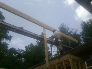 Carpenter setting a ridge beam over a new addition frame — Ice Dam Removal by Roofing Brothers in Chino Hills
