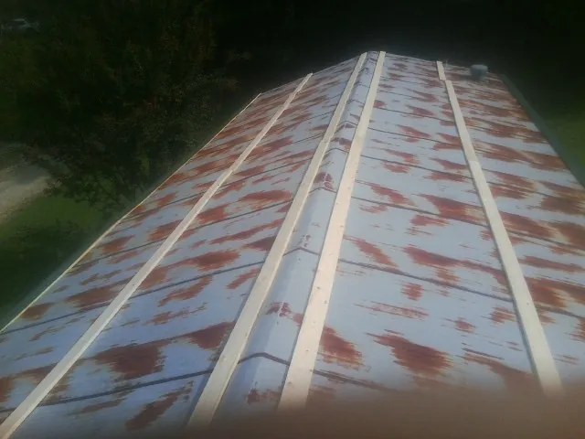 Rusted metal roof panels with new wood purlins before replacement — Storm Damage Roof Repair in Chino Hills by Roofing Brothers
