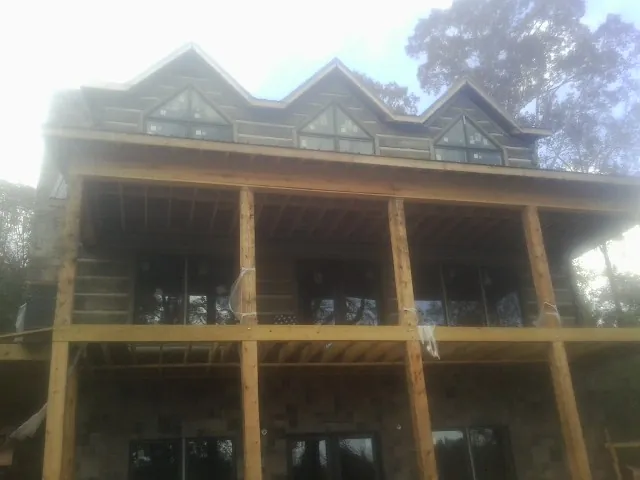 Dormers and porch framing on a large log home under construction — Roof Coating work by our crew in Chino Hills